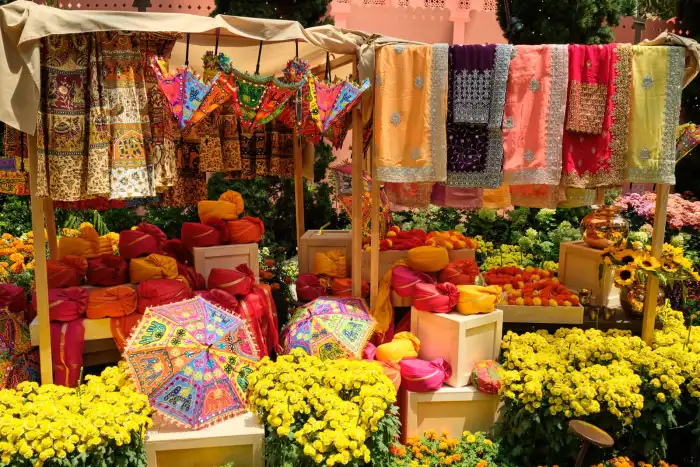 Block-printed textiles and flowers stacked at a Rajasthan bazaar
